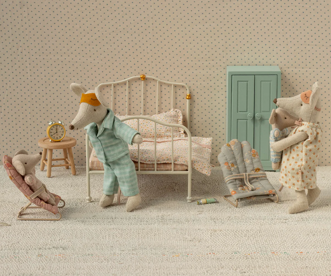 Miniature scene with stuffed animals in a room setting, including a bed and furniture.
