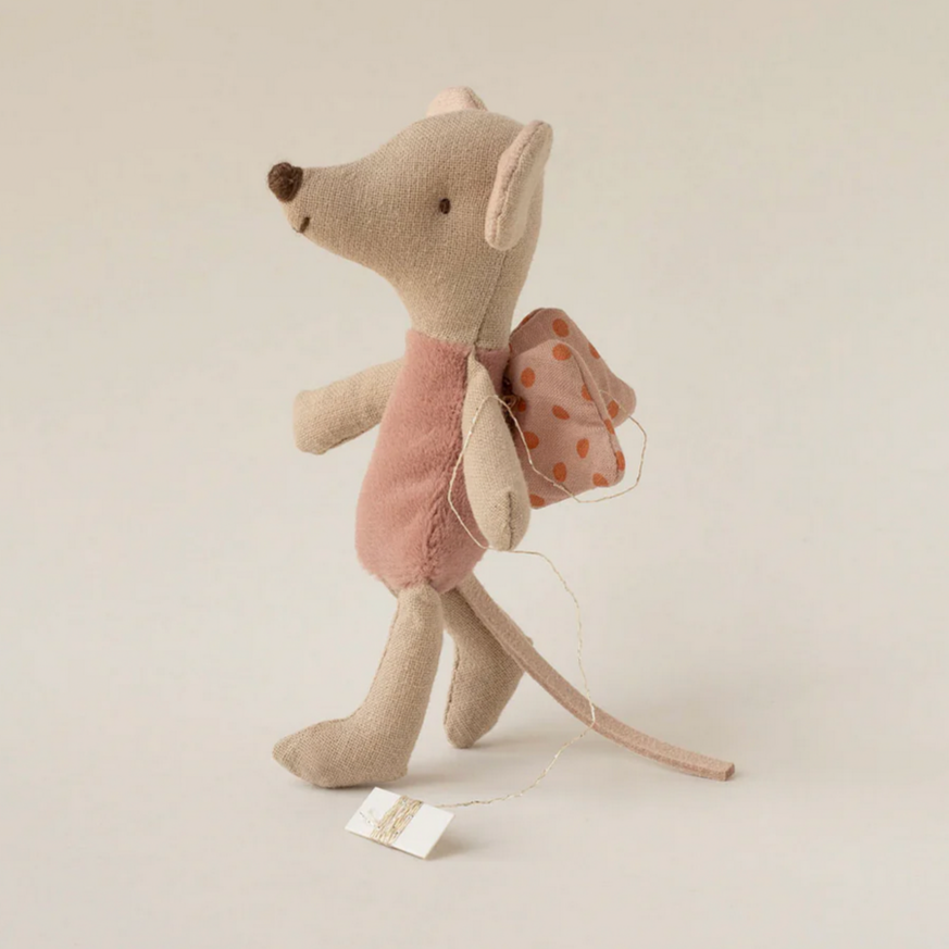 Stuffed mouse toy with a pink bow on a light beige background