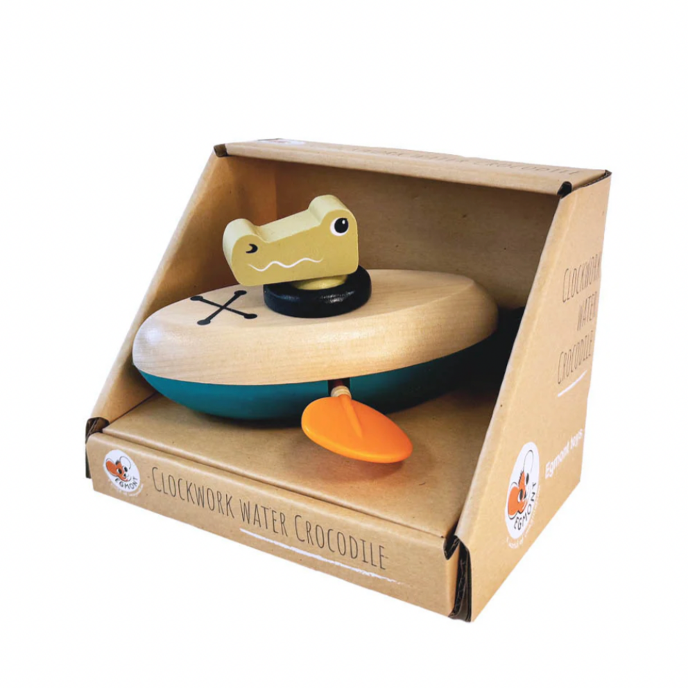 Wooden toy crocodile in a cardboard box on a white background
