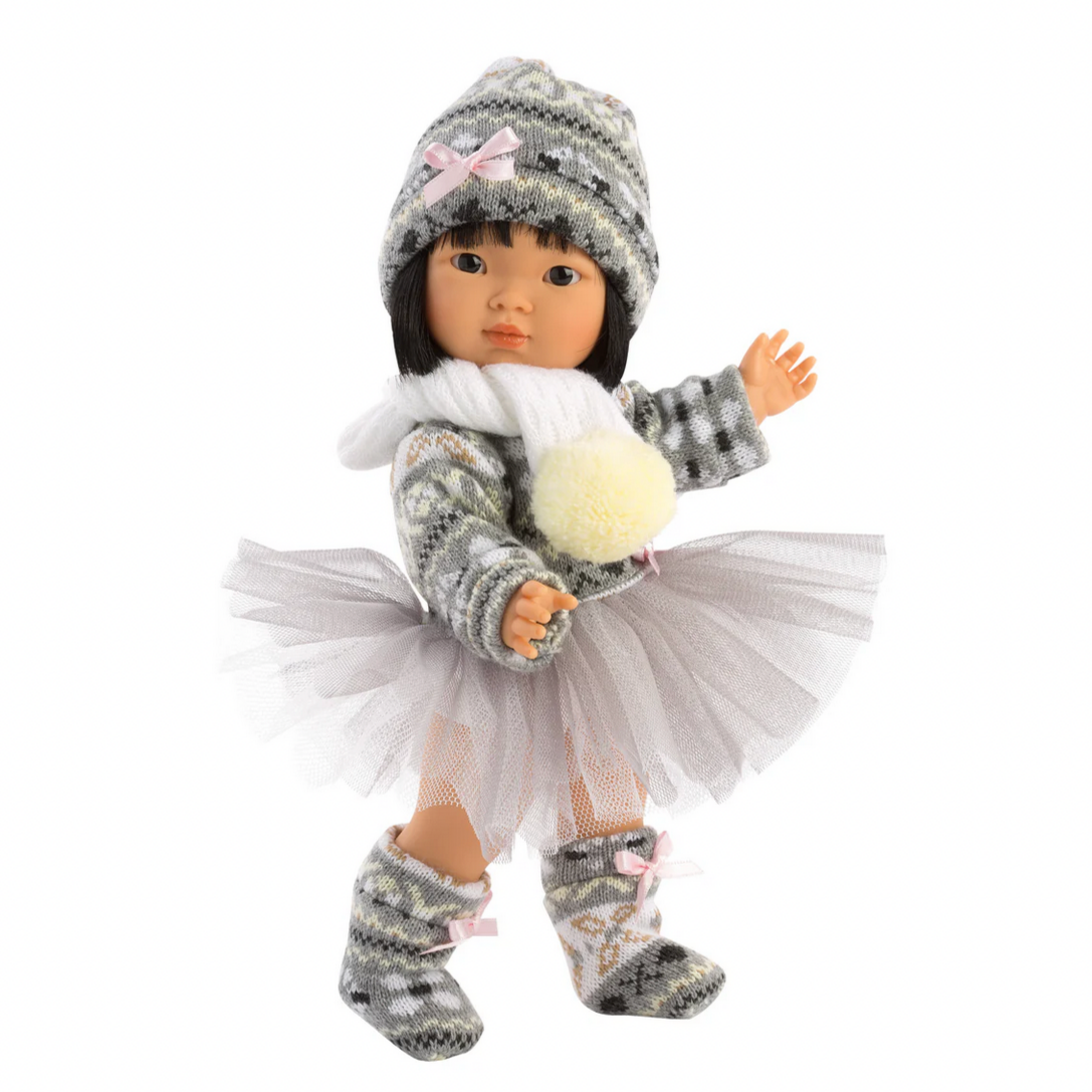 Doll wearing a winter outfit with a hat, scarf, and boots on a white background.