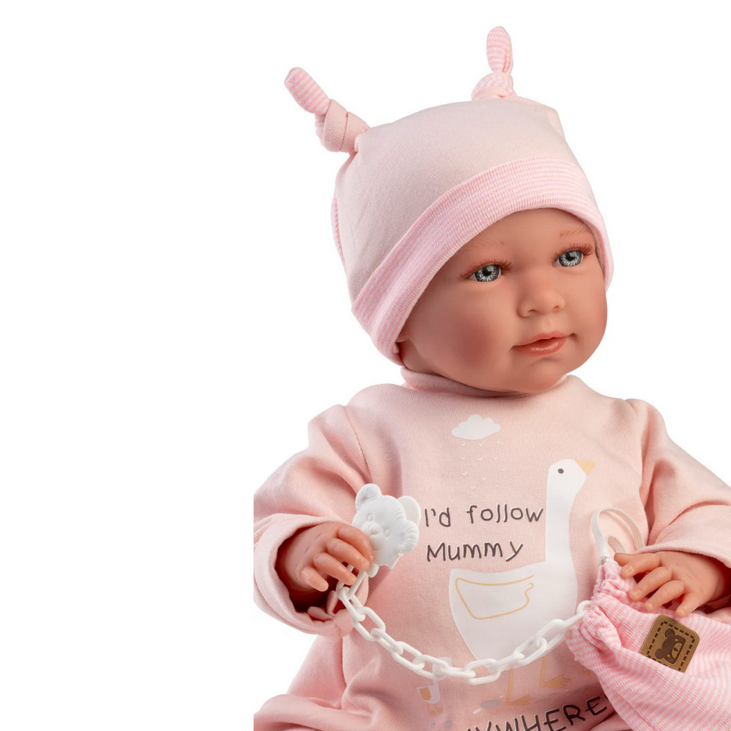 Baby doll wearing a pink outfit and hat with text on a white background