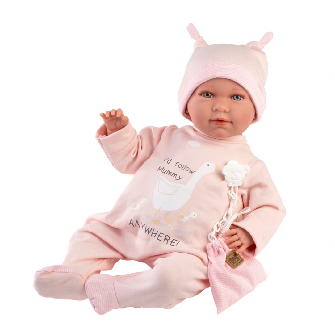 Baby doll in pink outfit with matching hat on a white background