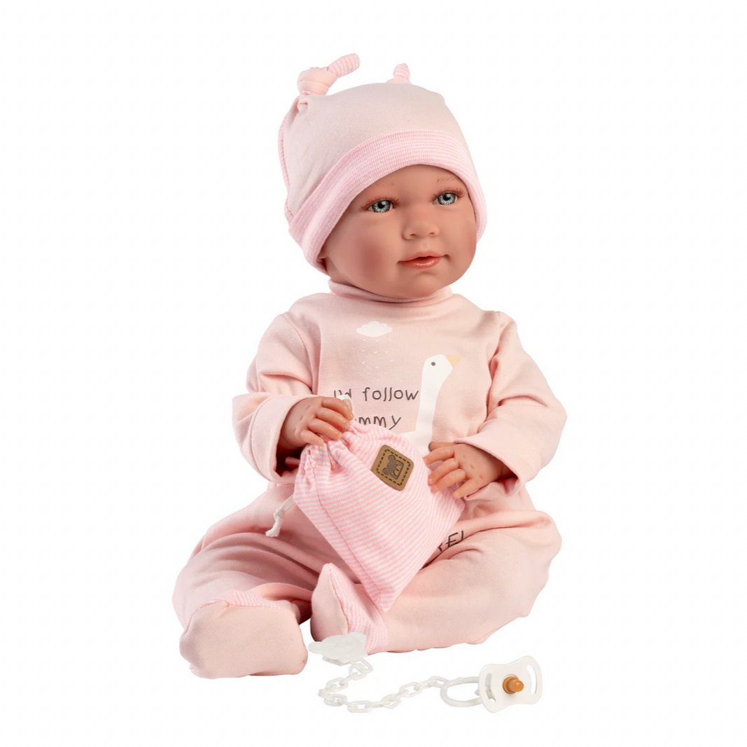 Baby doll in pink outfit with matching hat on a white background