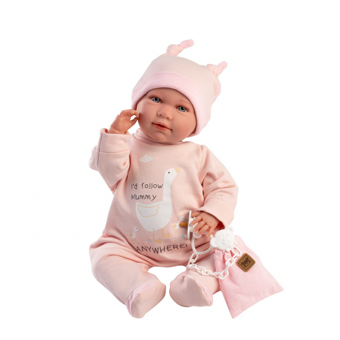 Baby doll in pink outfit with hat and toy on a white background
