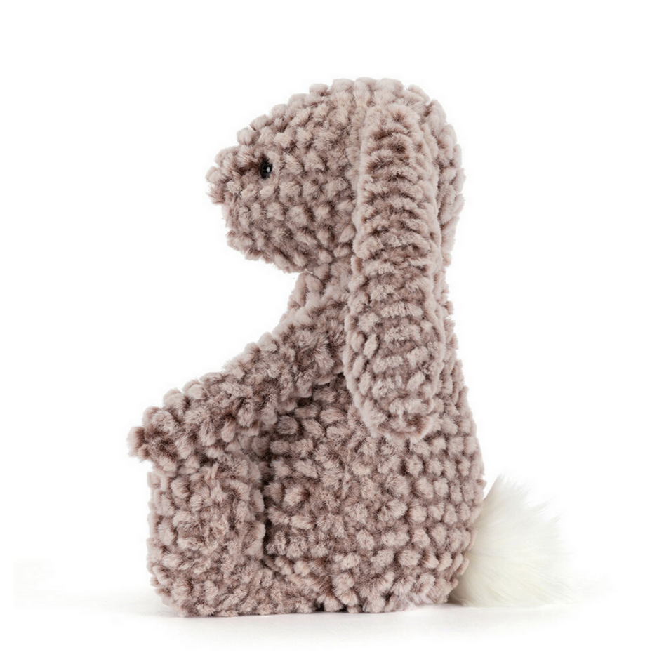 Plush toy resembling a rabbit with a textured surface on a white background