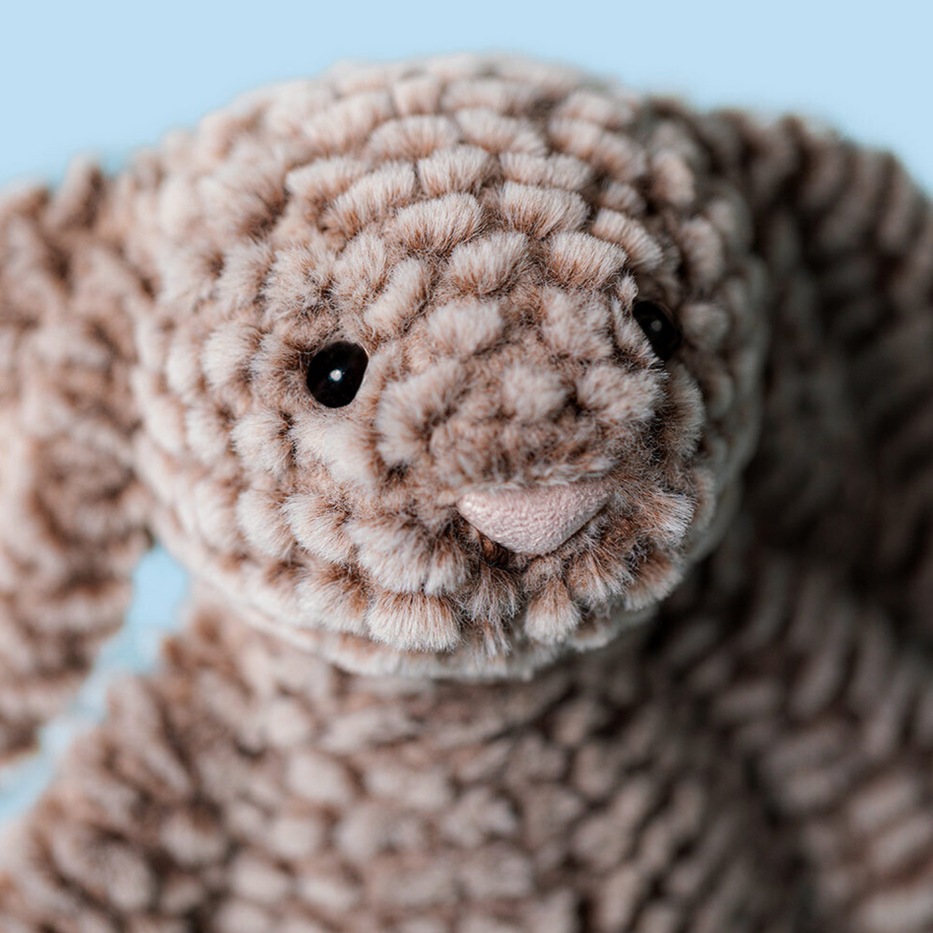 Close-up of a brown textured animal toy with a light blue background