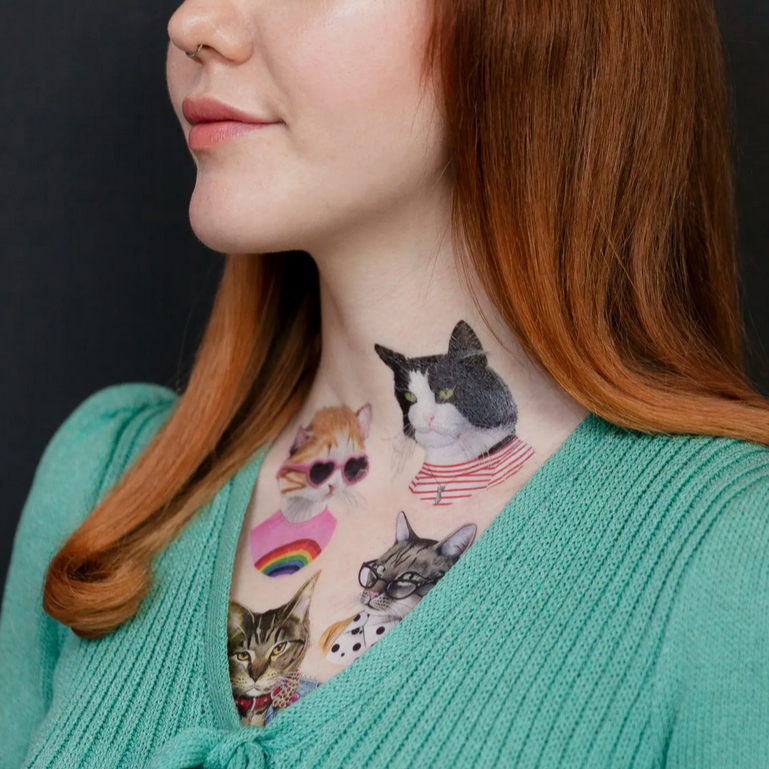 Woman with cat-themed tattoos on her neck against a black background