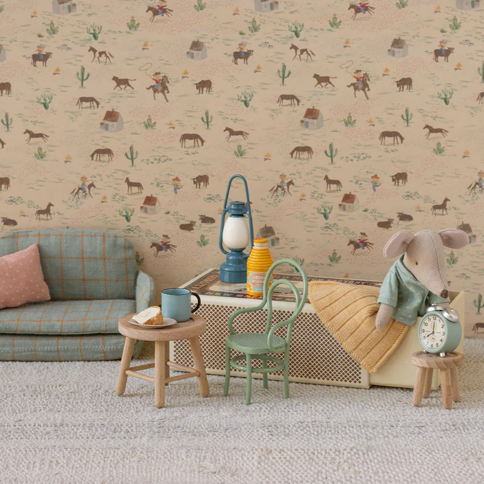Children's room with patterned wallpaper, sofa, and toys.