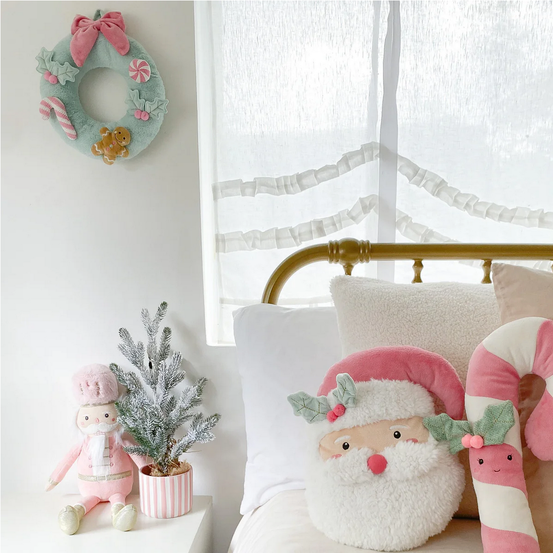 Decorative items including a wreath, plush toys, and a small plant on a white surface.