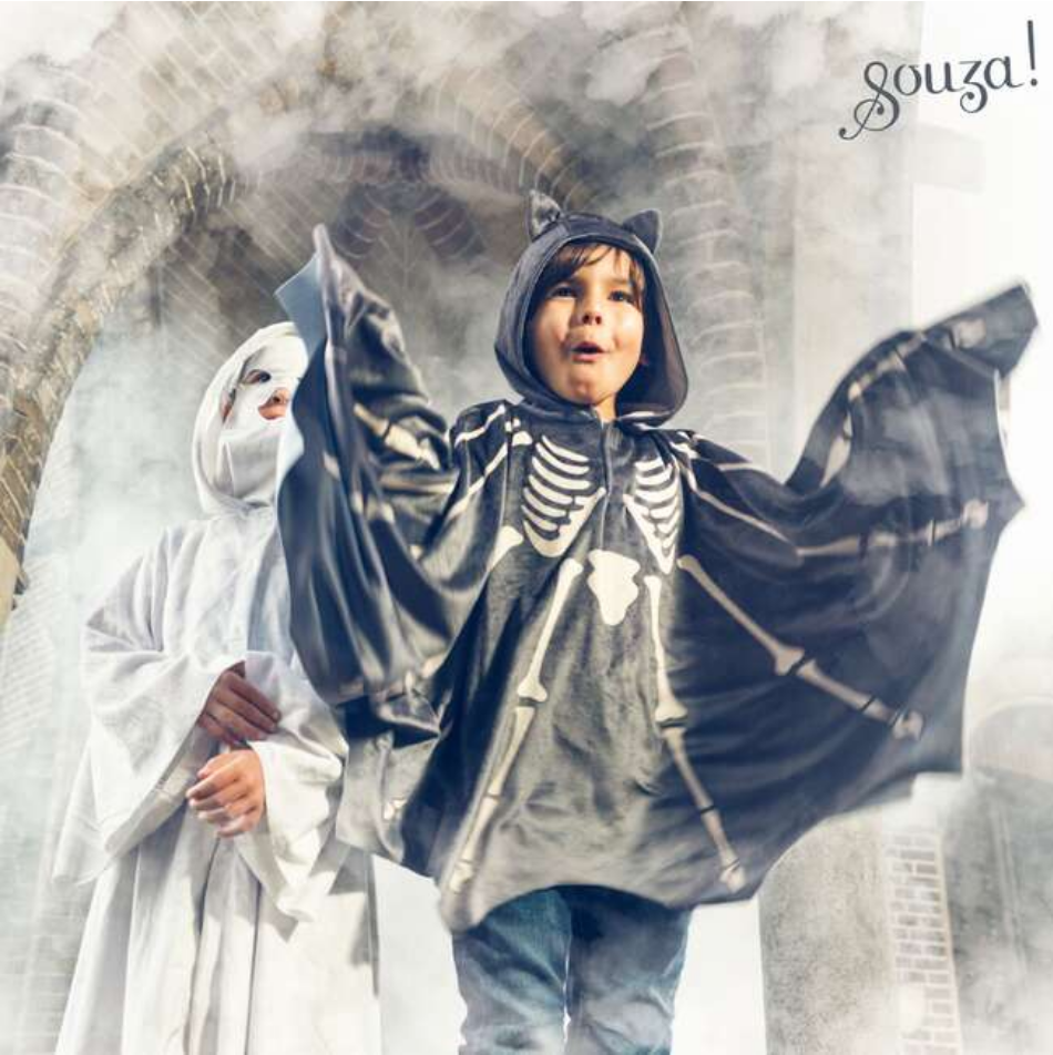 Child wearing a skeleton-themed cape with a blurred background