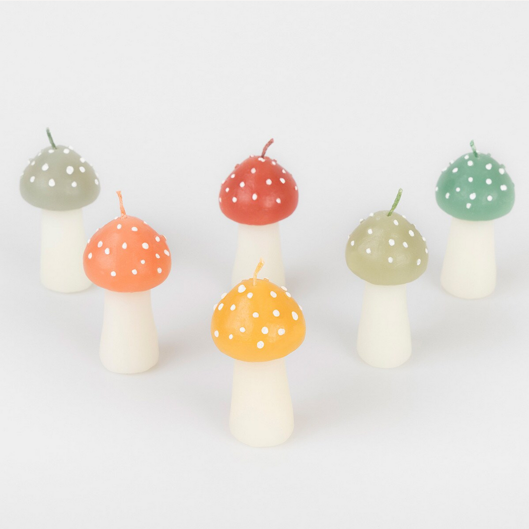 Set of colorful mushroom-shaped candles on a white background