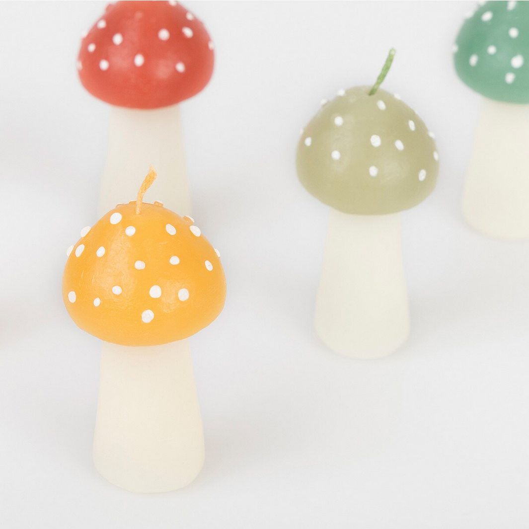Set of colorful mushroom-shaped candles on a white background