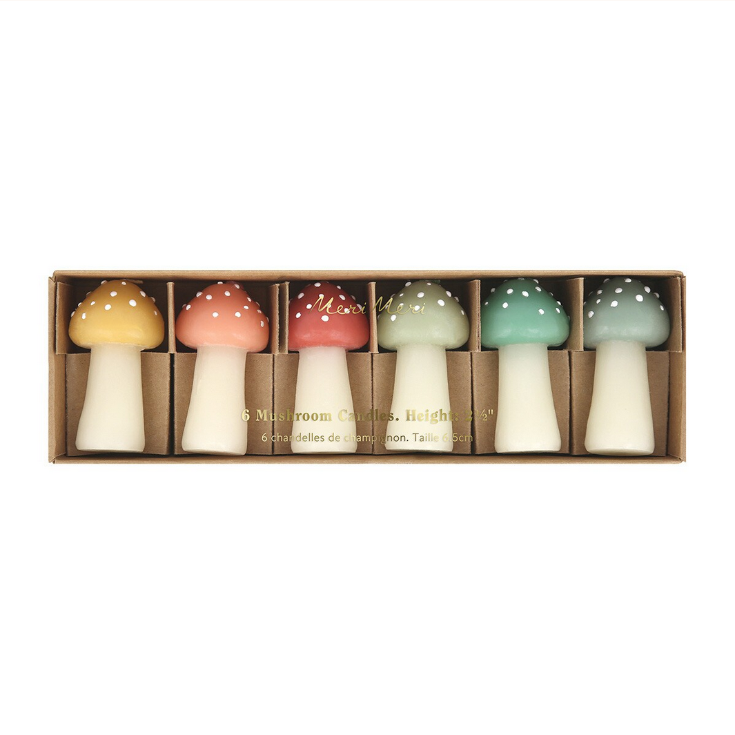 Set of six mushroom-shaped candles in a box on a white background