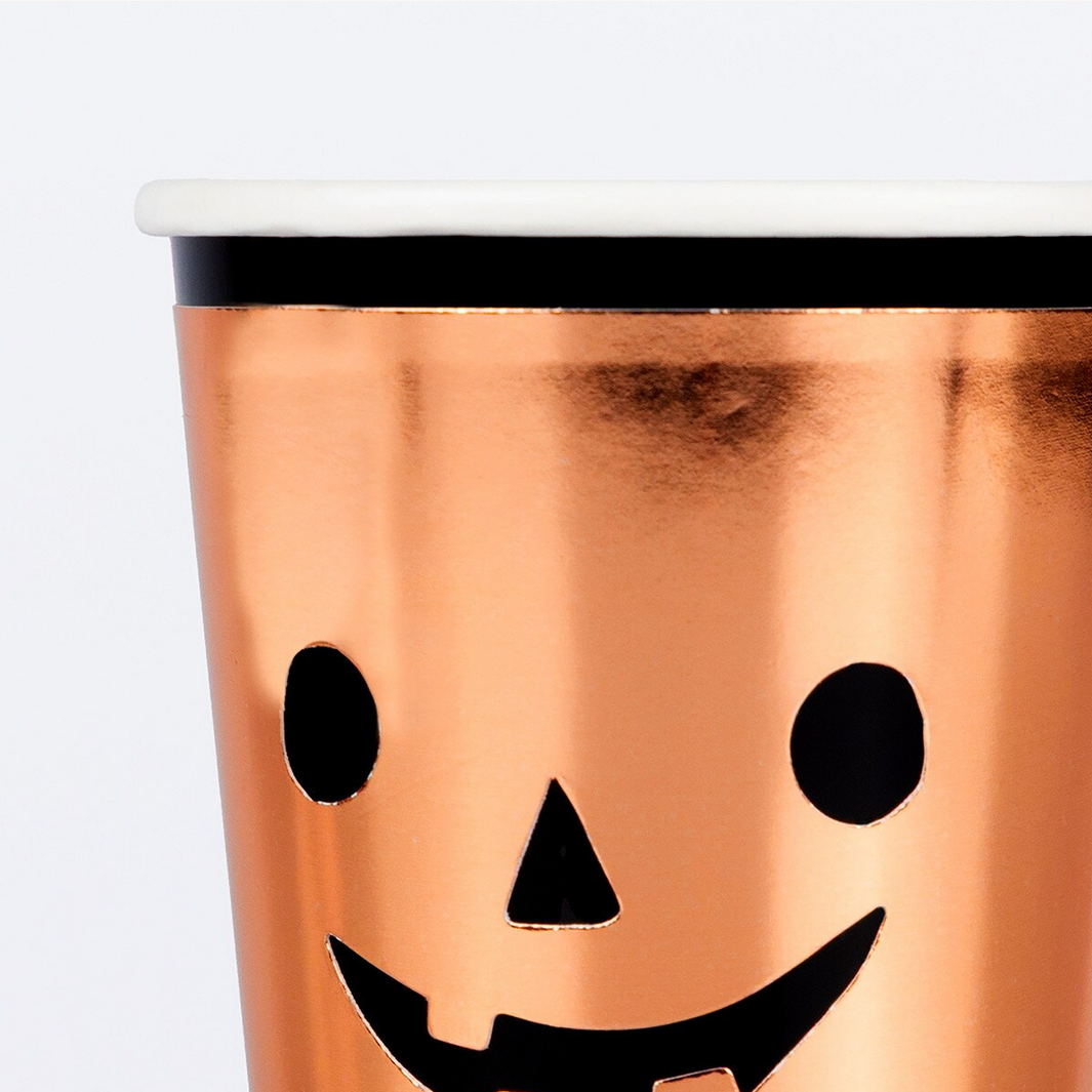 Copper-colored tumbler with a jack-o'-lantern face design on a white background
