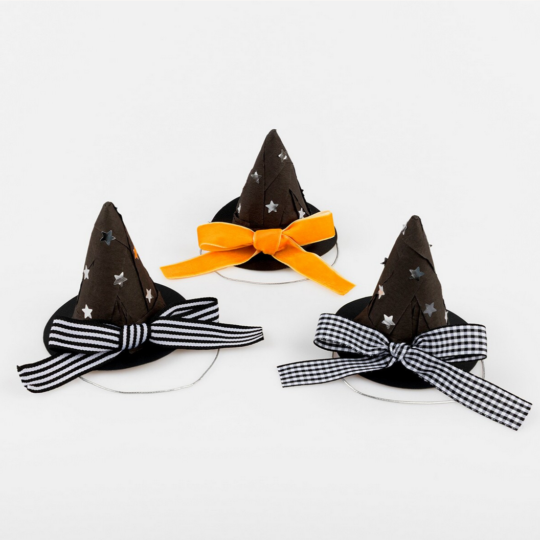 Three Halloween-themed witch hats with decorative bows on a white background