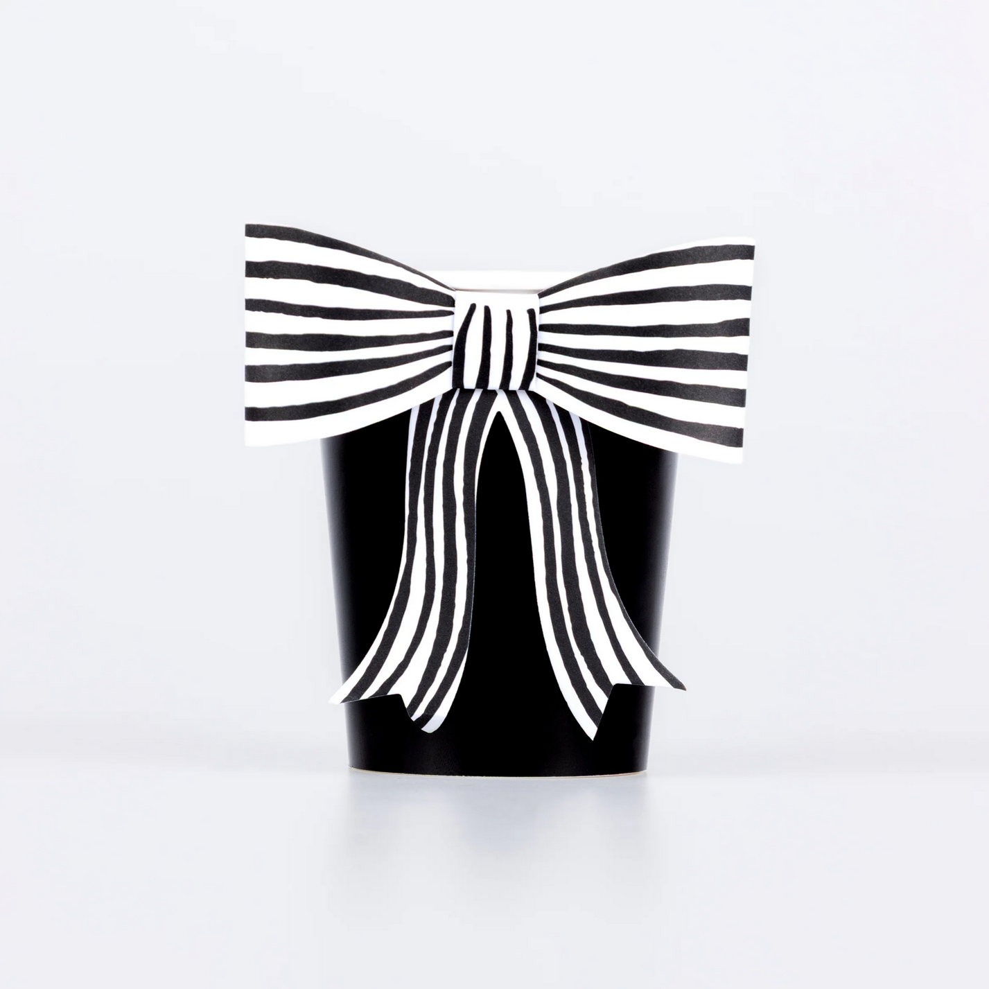 Black container with a large white bow on a white background
