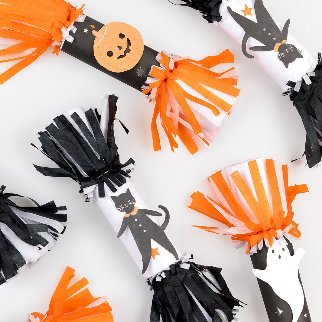 Halloween-themed pom-poms with black, orange, and white designs on a white background.