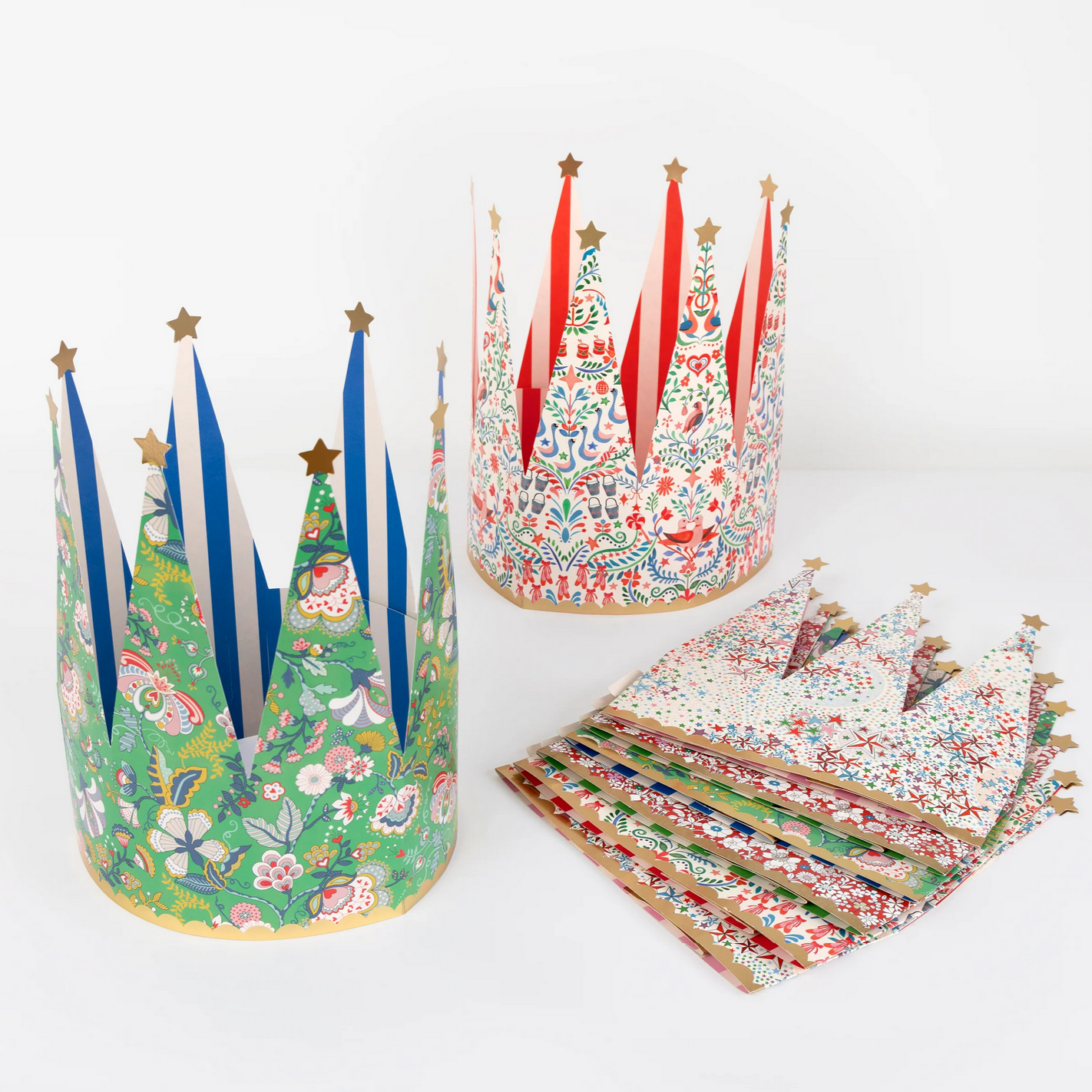 Colorful paper crowns with floral and nature-themed designs on a white background