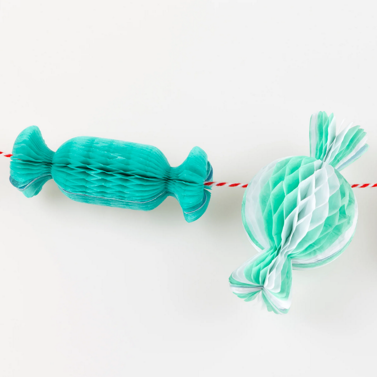 Two paper candy decorations, one blue and one green, on a white background.