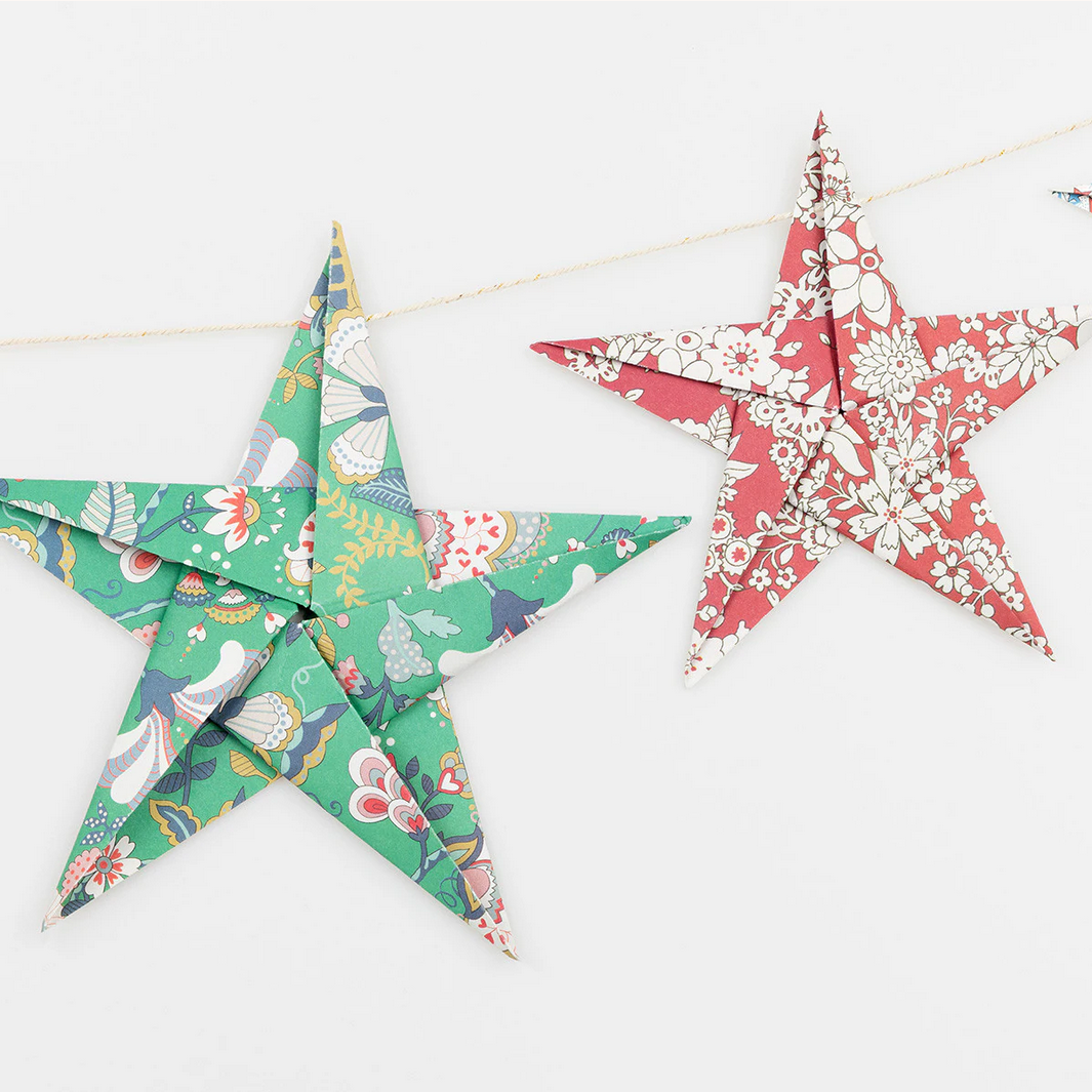 Two decorative paper stars with floral patterns on a white background