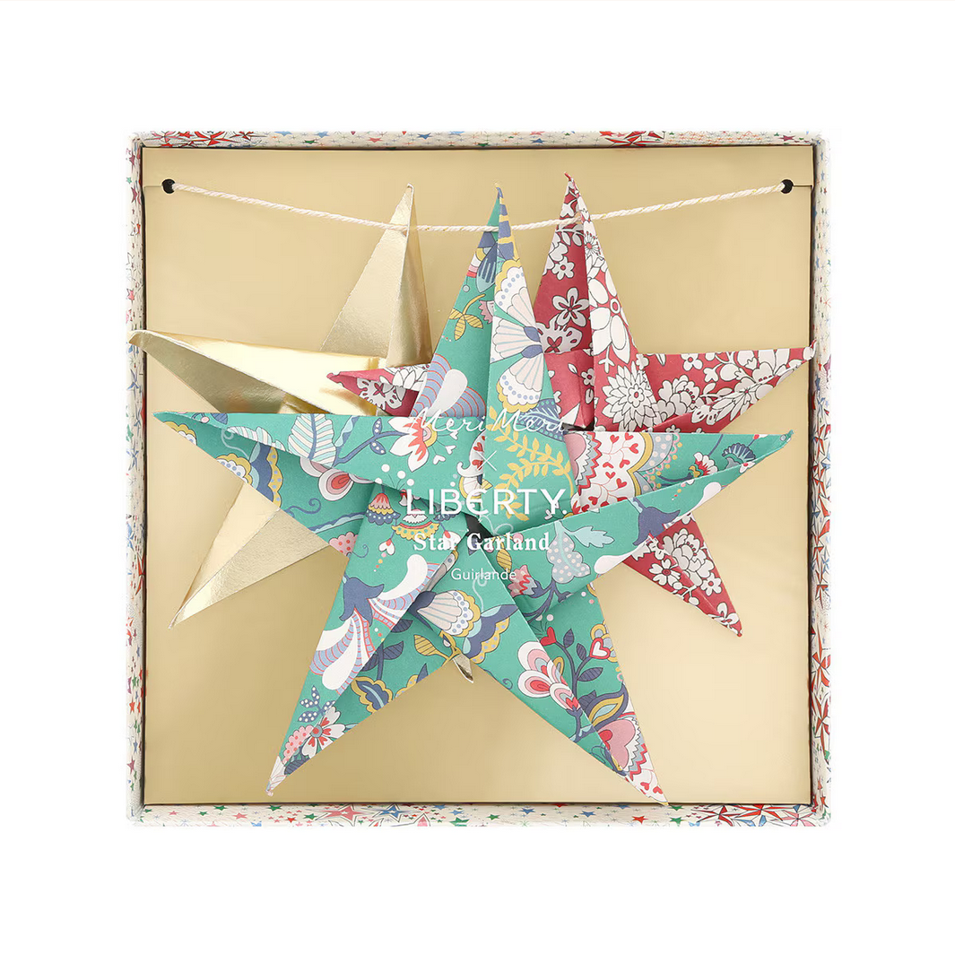 Colorful star-shaped Liberty fabric garland in a decorative box on a white background