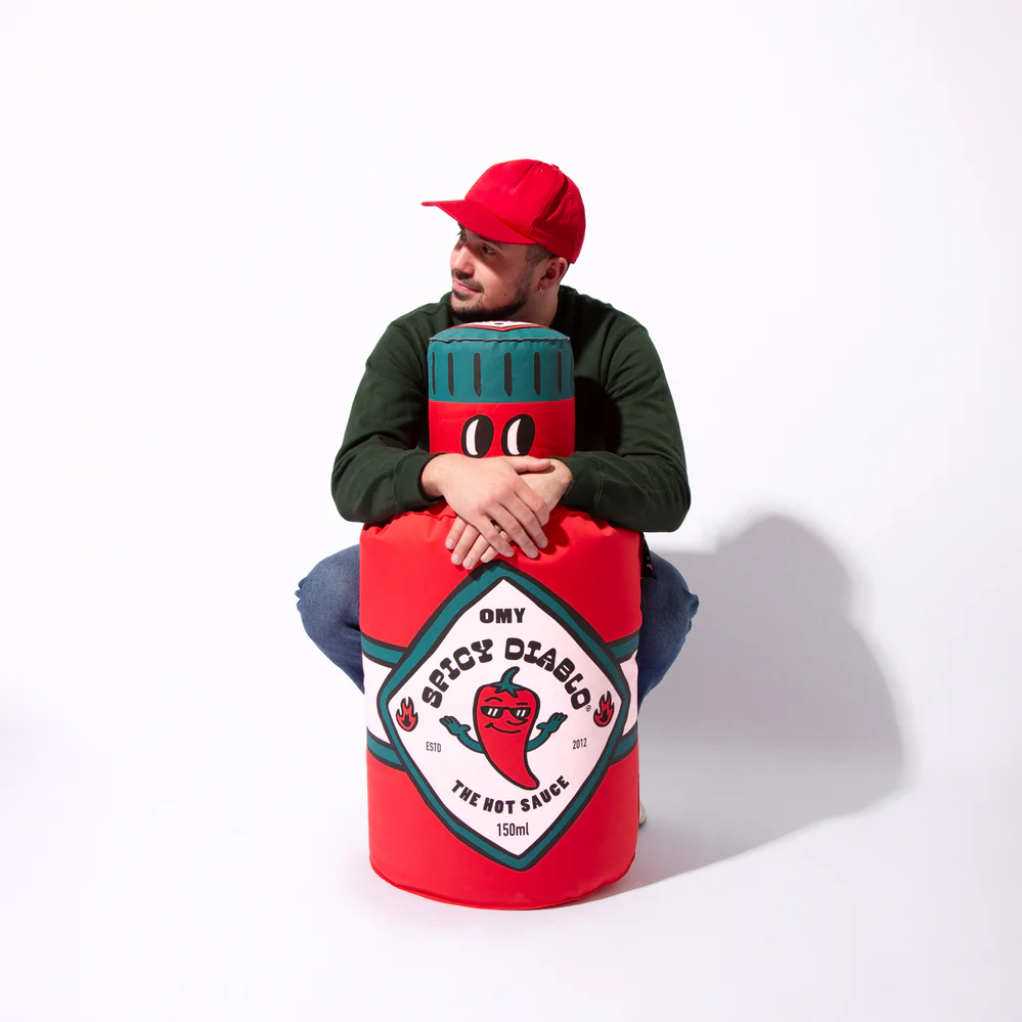 Person sitting on a large red container with a cartoon character design on a white background