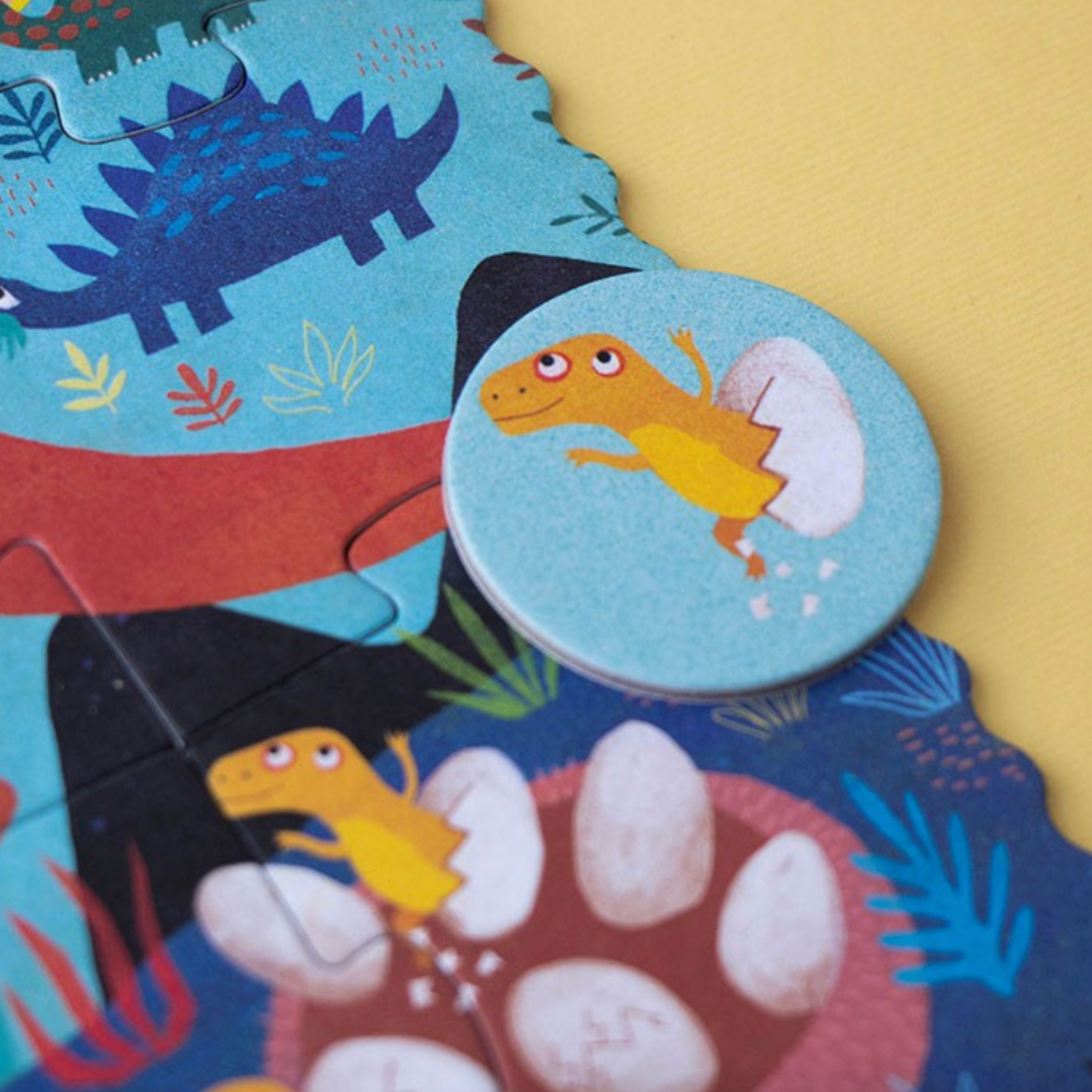 Children's dinosaur puzzle with a focus on a round piece featuring a yellow dinosaur.
