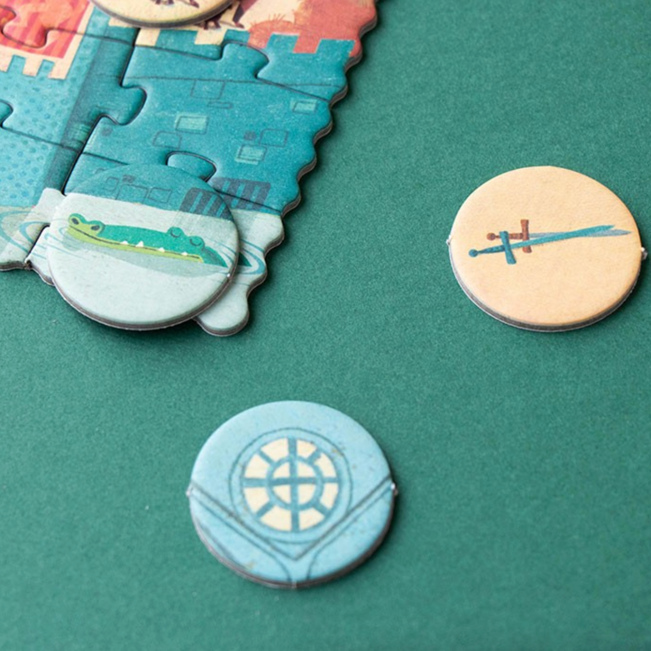 Two round decorative items on a green surface with puzzle piece design