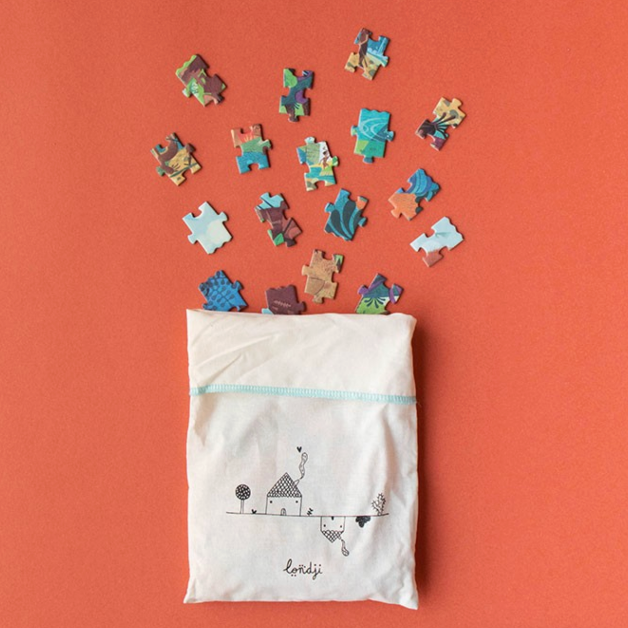 Colorful puzzle pieces spilling out of a white bag with a design on an orange background