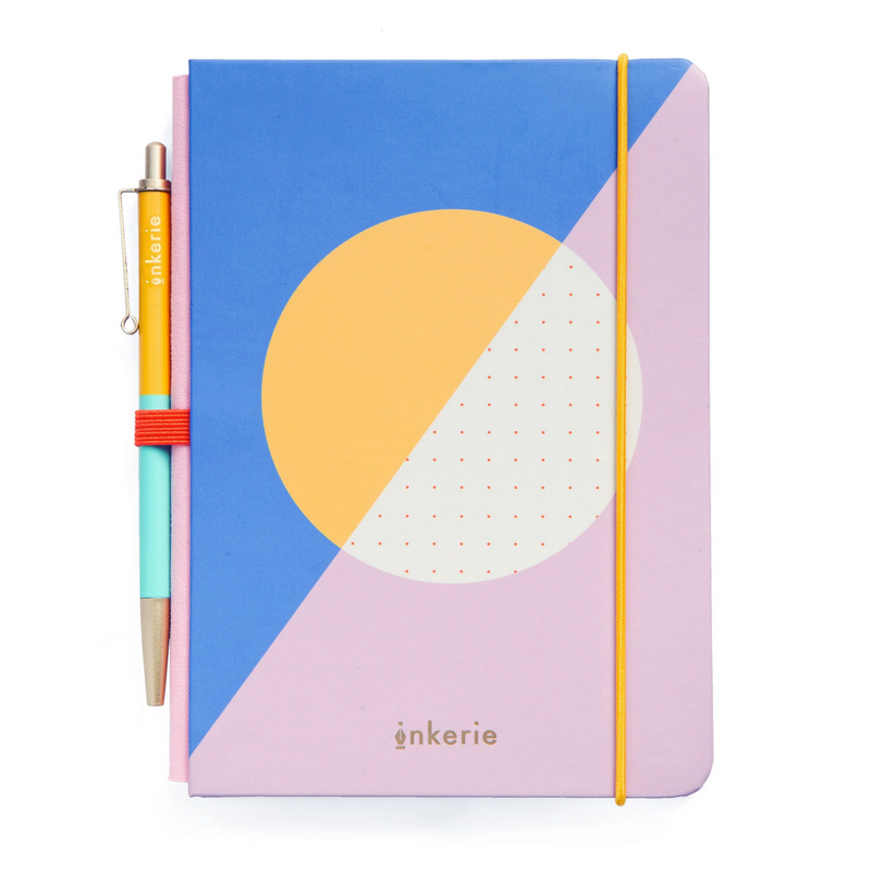 Notebook with geometric design and pen on a white background
