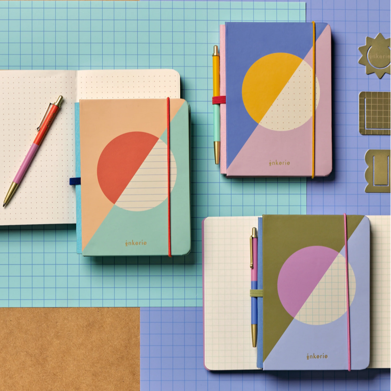 Colorful notebooks with geometric designs on a checkered surface