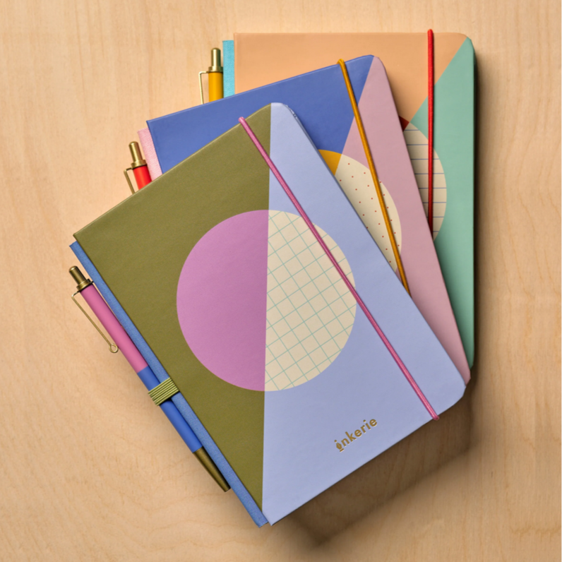Colorful notebooks with geometric designs on a wooden surface