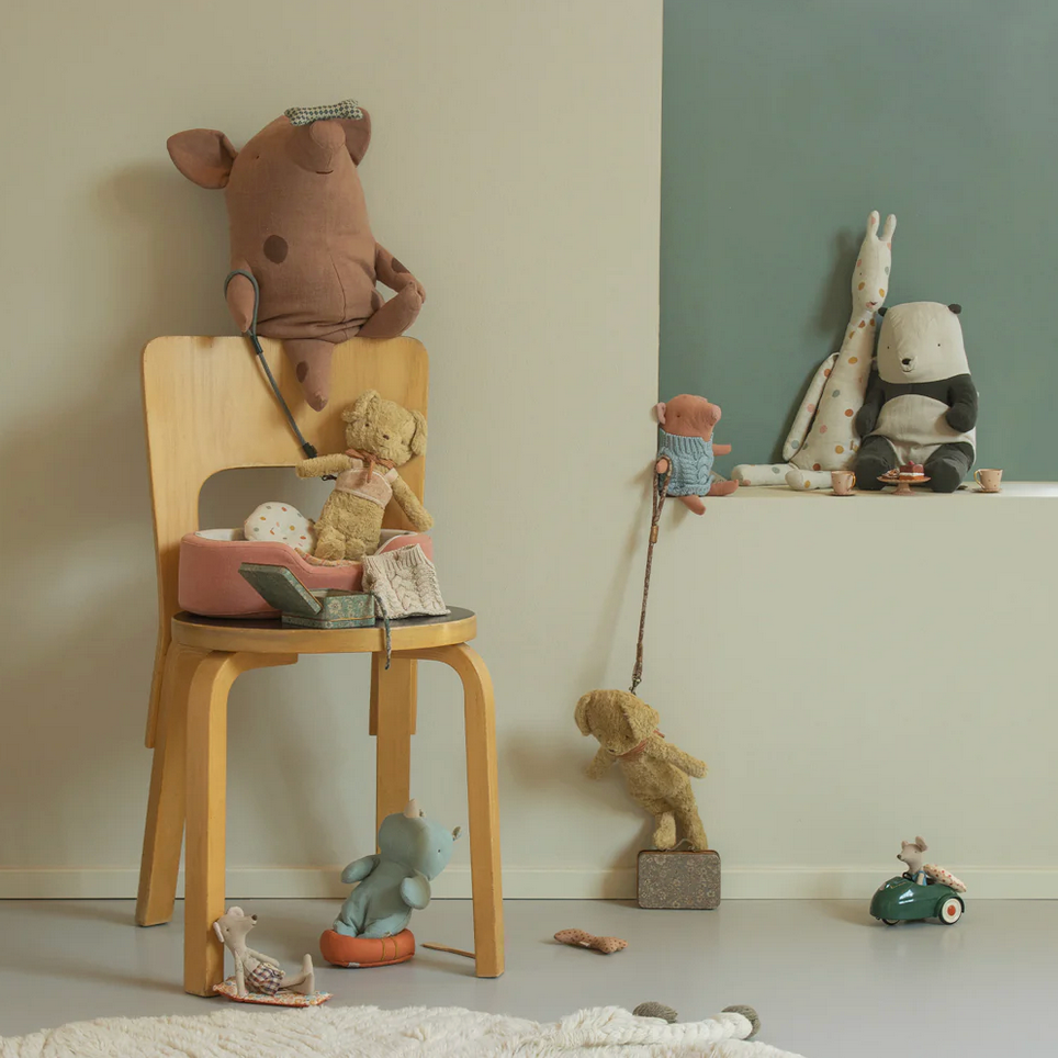 Children's toys on a chair and table against a neutral wall