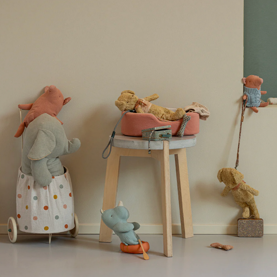 Children's toys including teddy bears and a small stool on a light-colored floor.