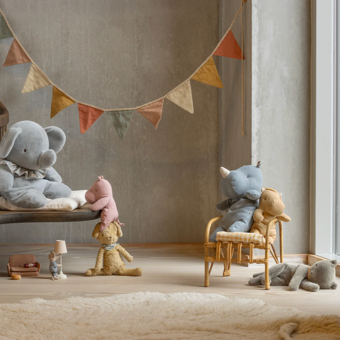 Children's room with plush toys and a banner, featuring a website header at the top.