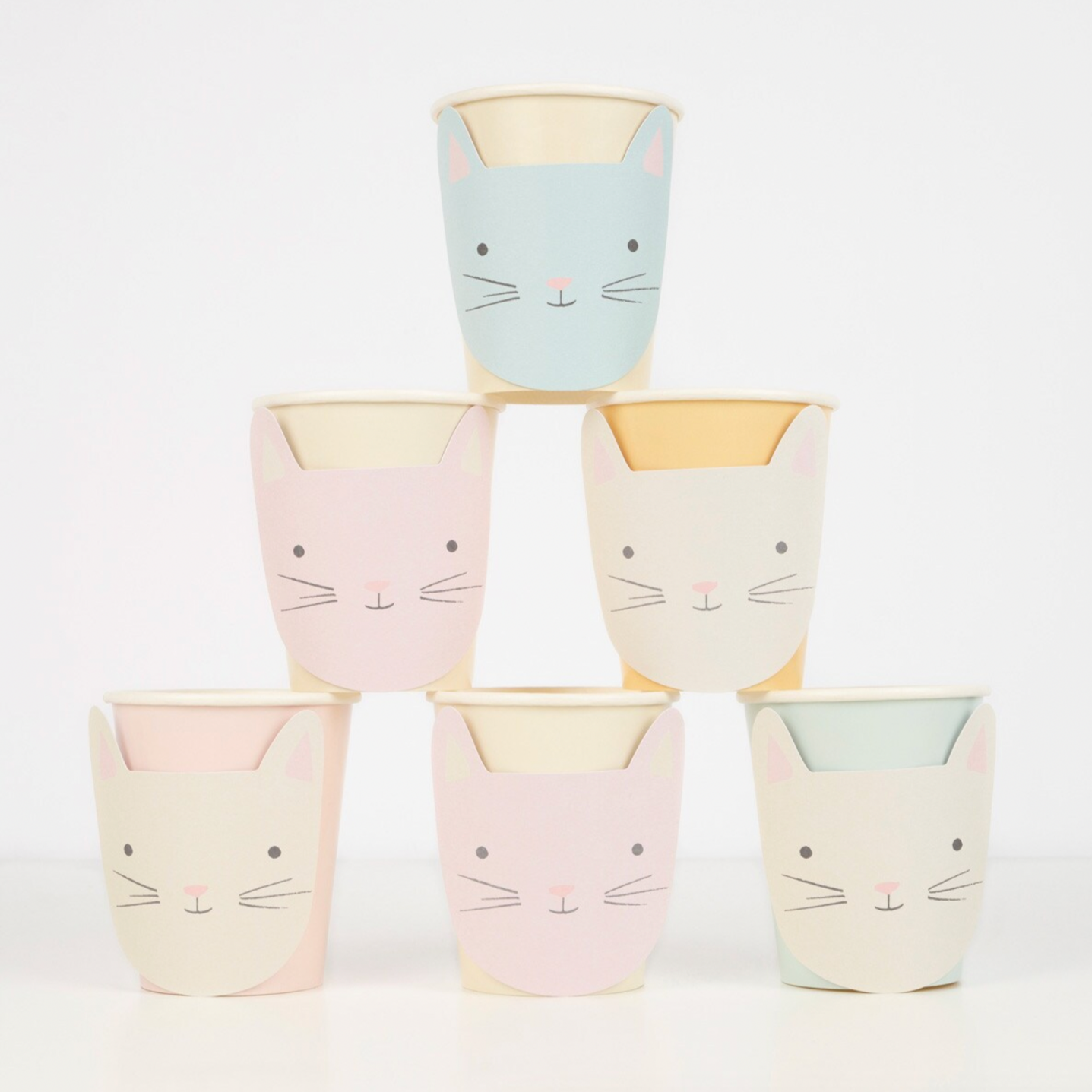 A collection of pastel-colored paper cups with a design of a kitten's face on them, arranged in a pyramid shape.