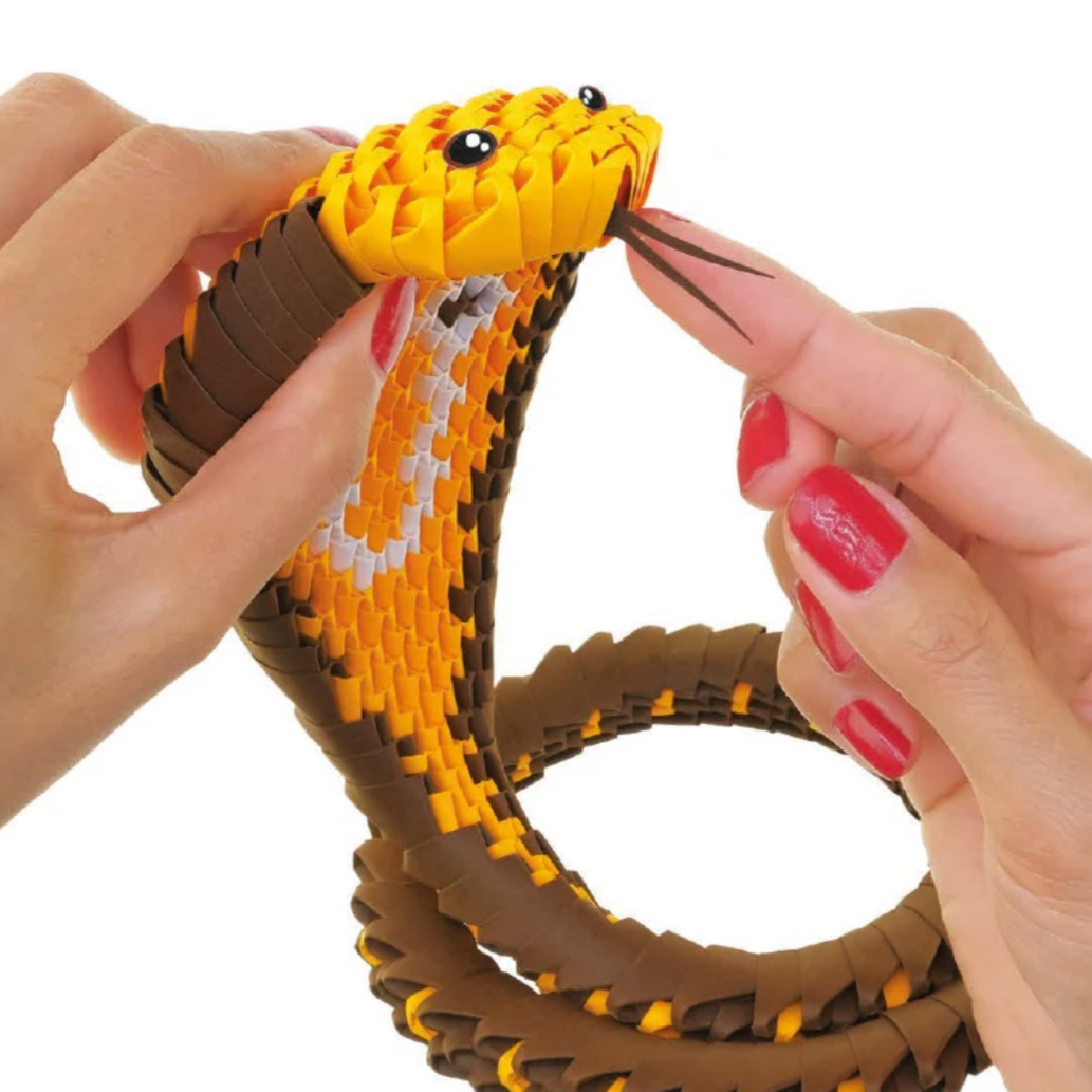 Hand holding a toy cobra with a white background