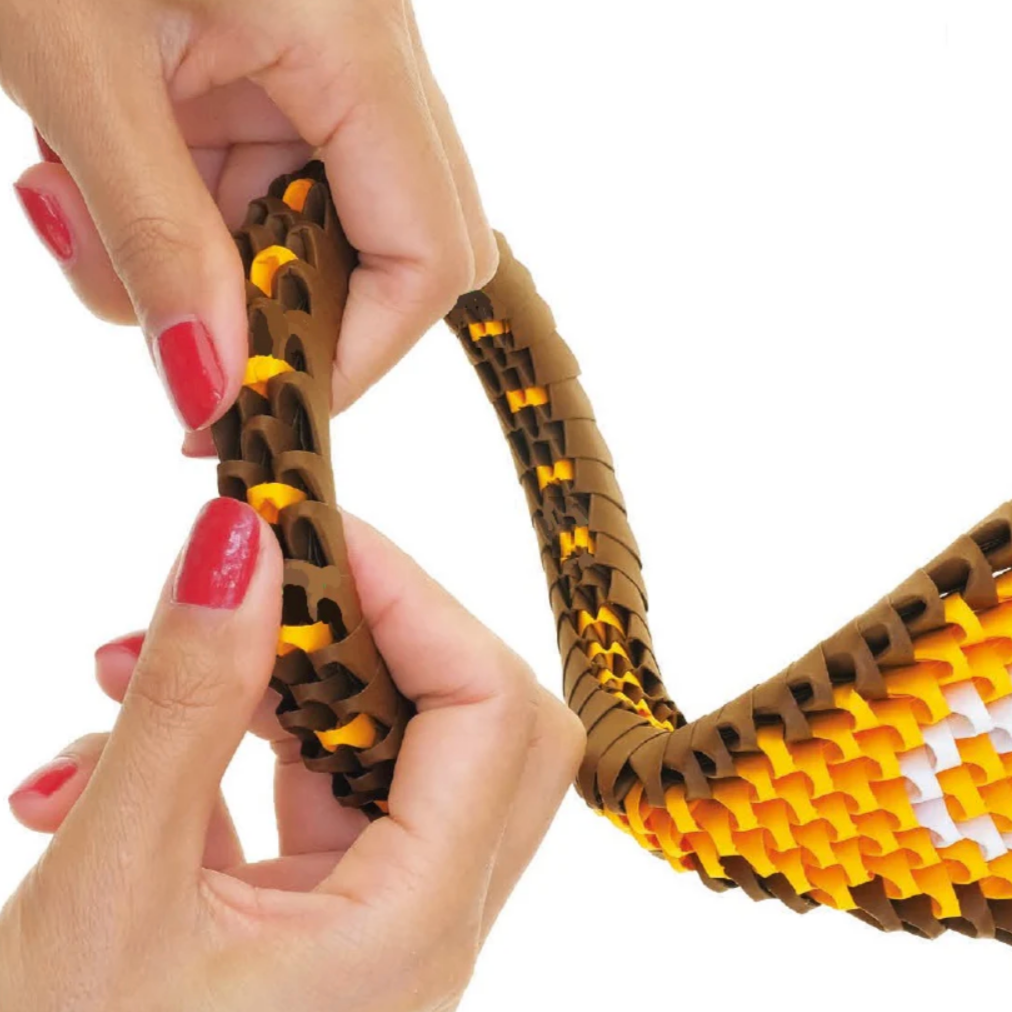 Hand holding a snake-shaped toy with colorful patterns