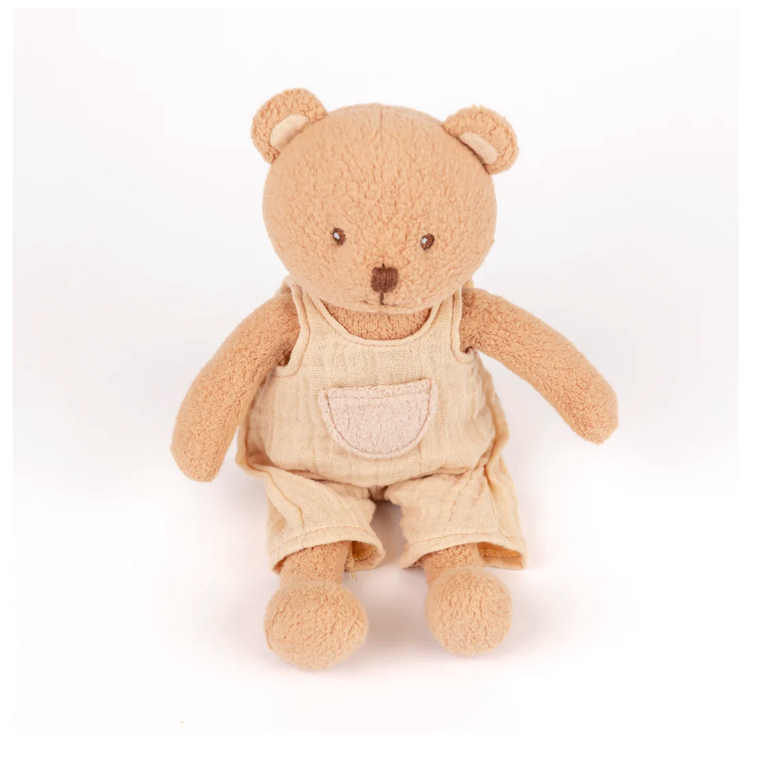 Plush teddy bear wearing beige overalls on a white background