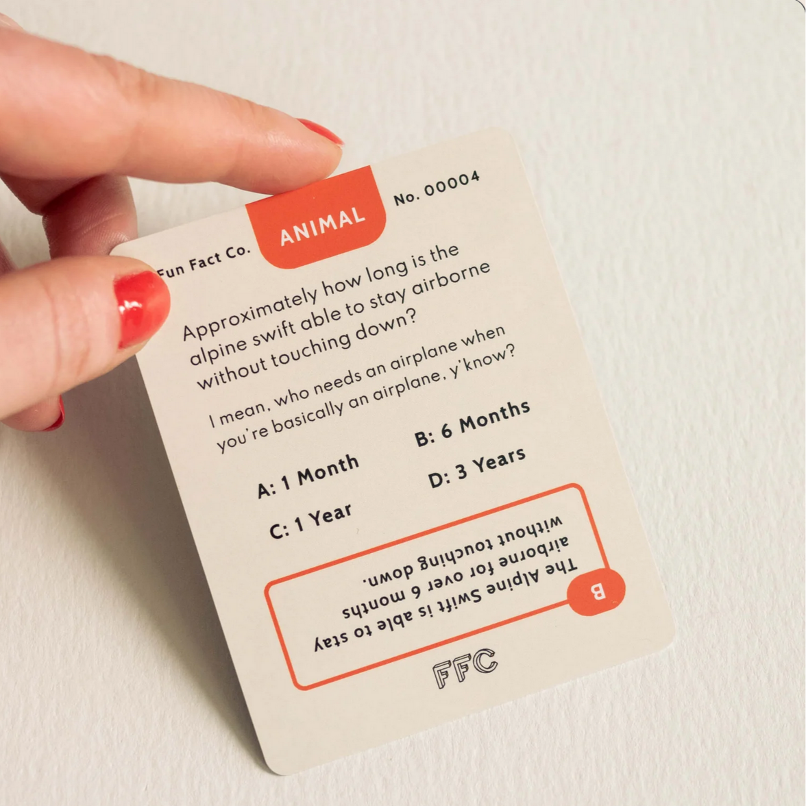 Card with trivia question about alpine swifts held by a hand