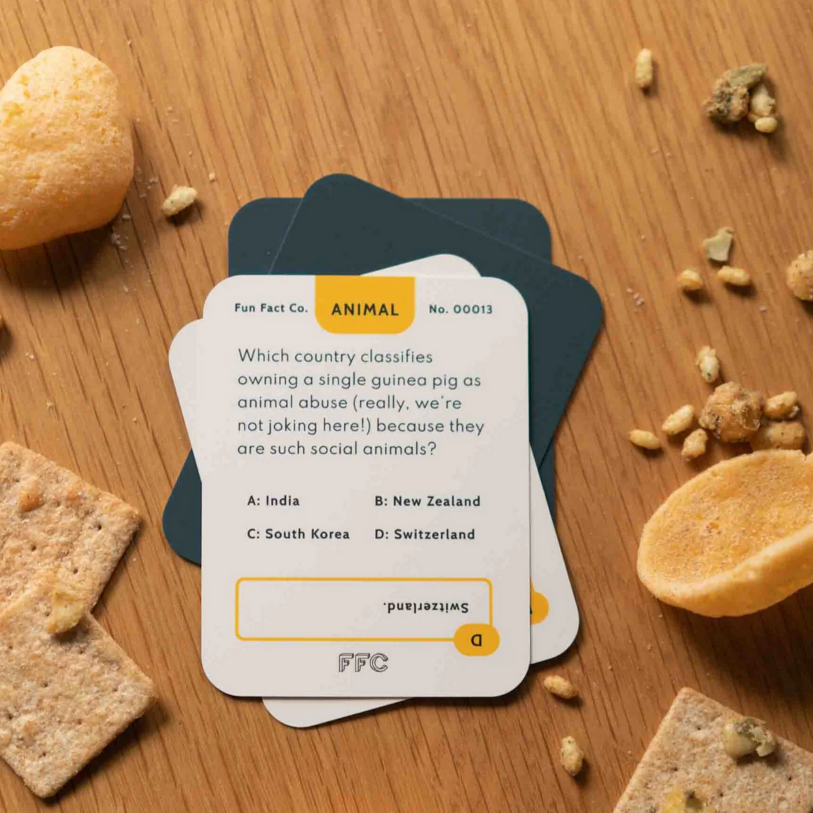 Card game question card on a wooden surface with snacks