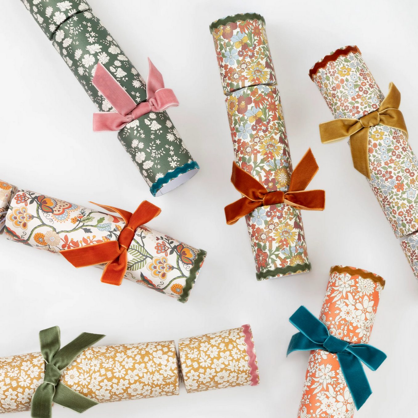 Decorative cracker rolls with floral patterns and colorful ribbons on a white background