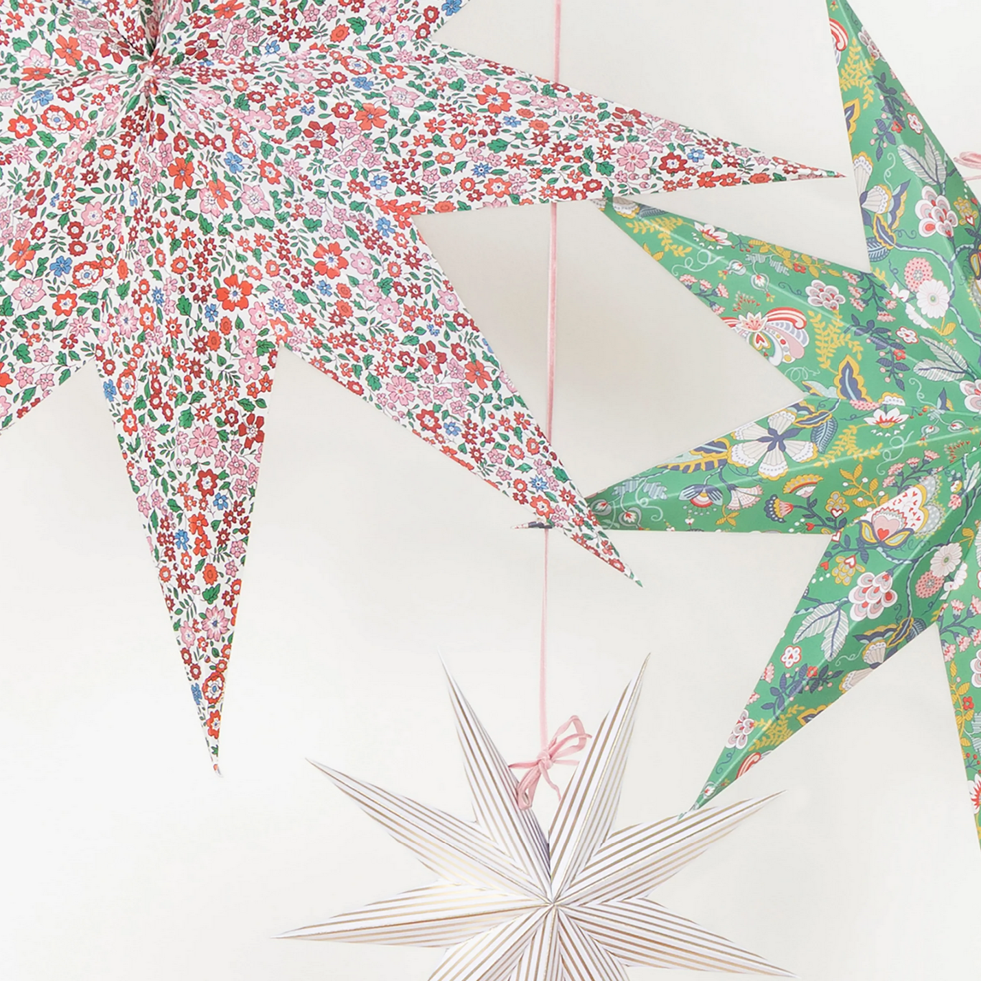 Three colorful star-shaped paper crafts on a white background