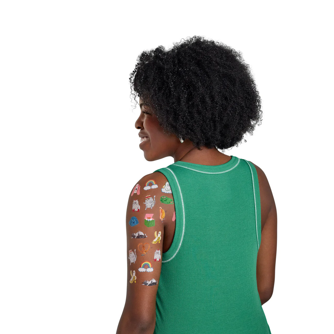 Woman wearing a green sleeveless top with colorful designs on her arm against a white background