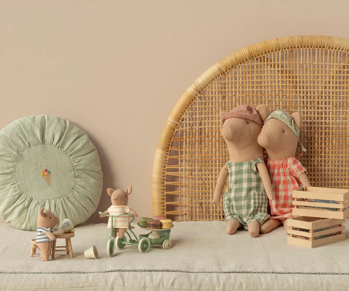 Children's room with stuffed animals, toys, and a decorative pillow on a bed.