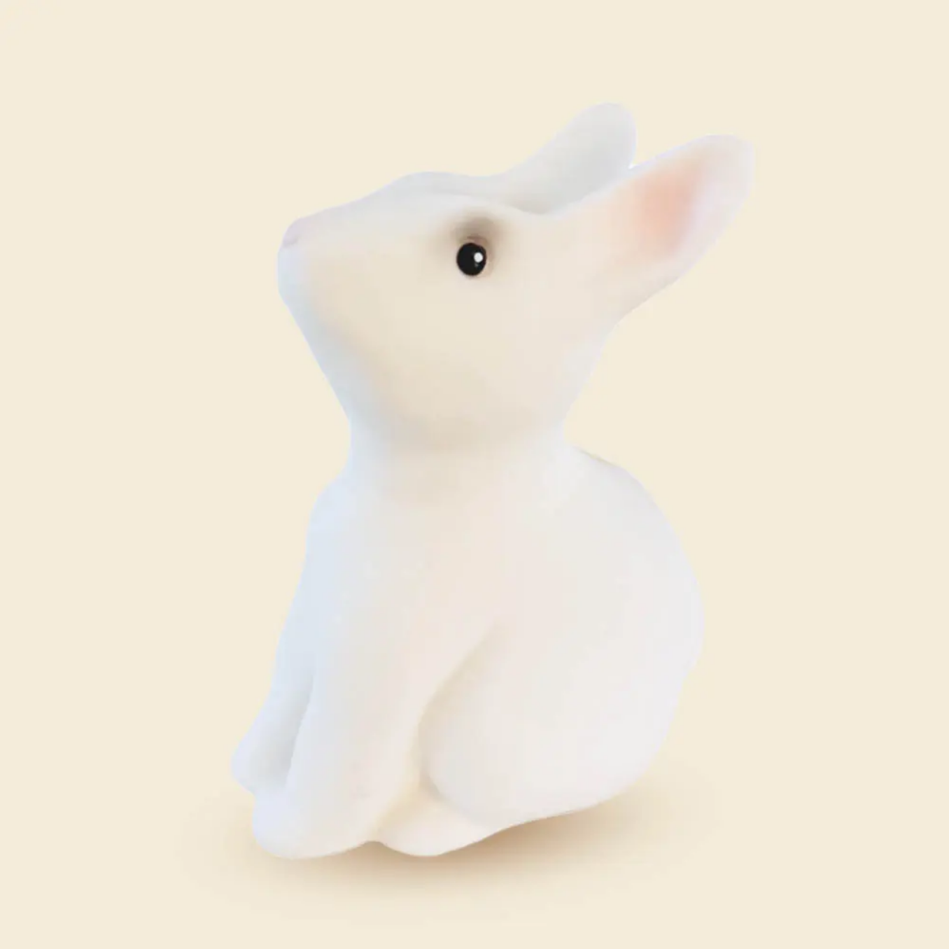 White plush mouse toy on a beige background