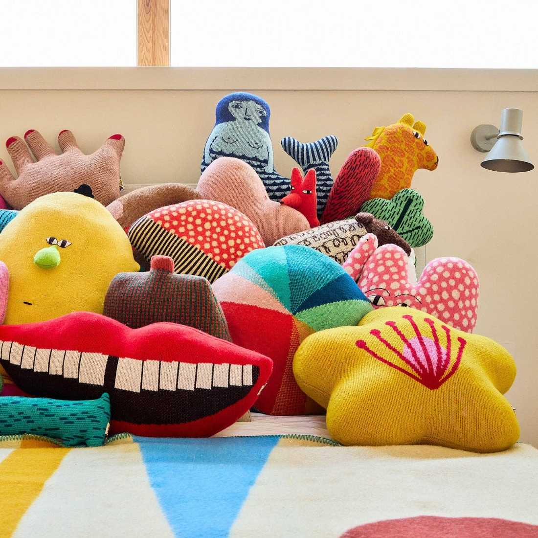 Colorful plush toys on a bed with a striped bedspread