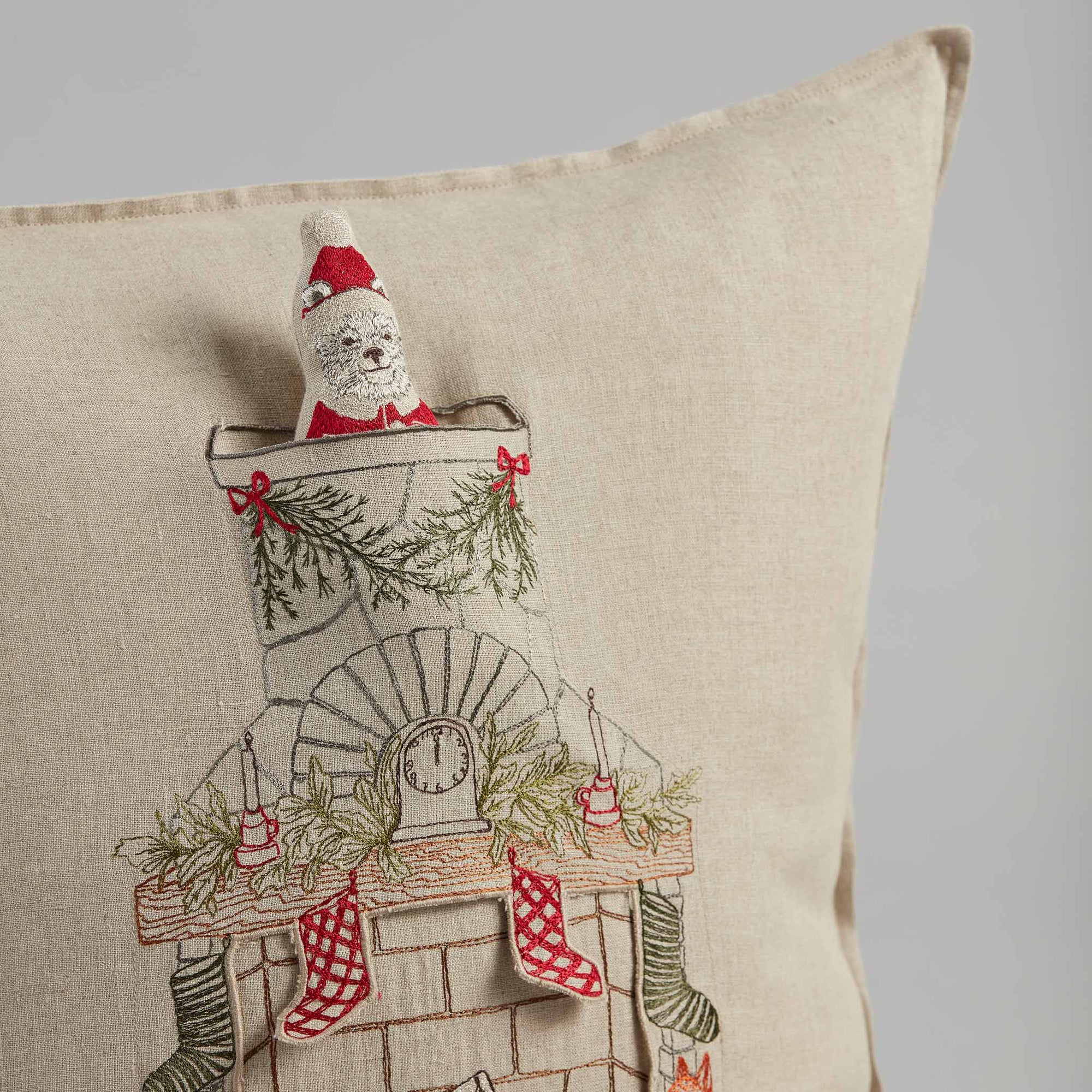 Decorative pillow with Christmas-themed design featuring a polar bear, stockings, and a clock.