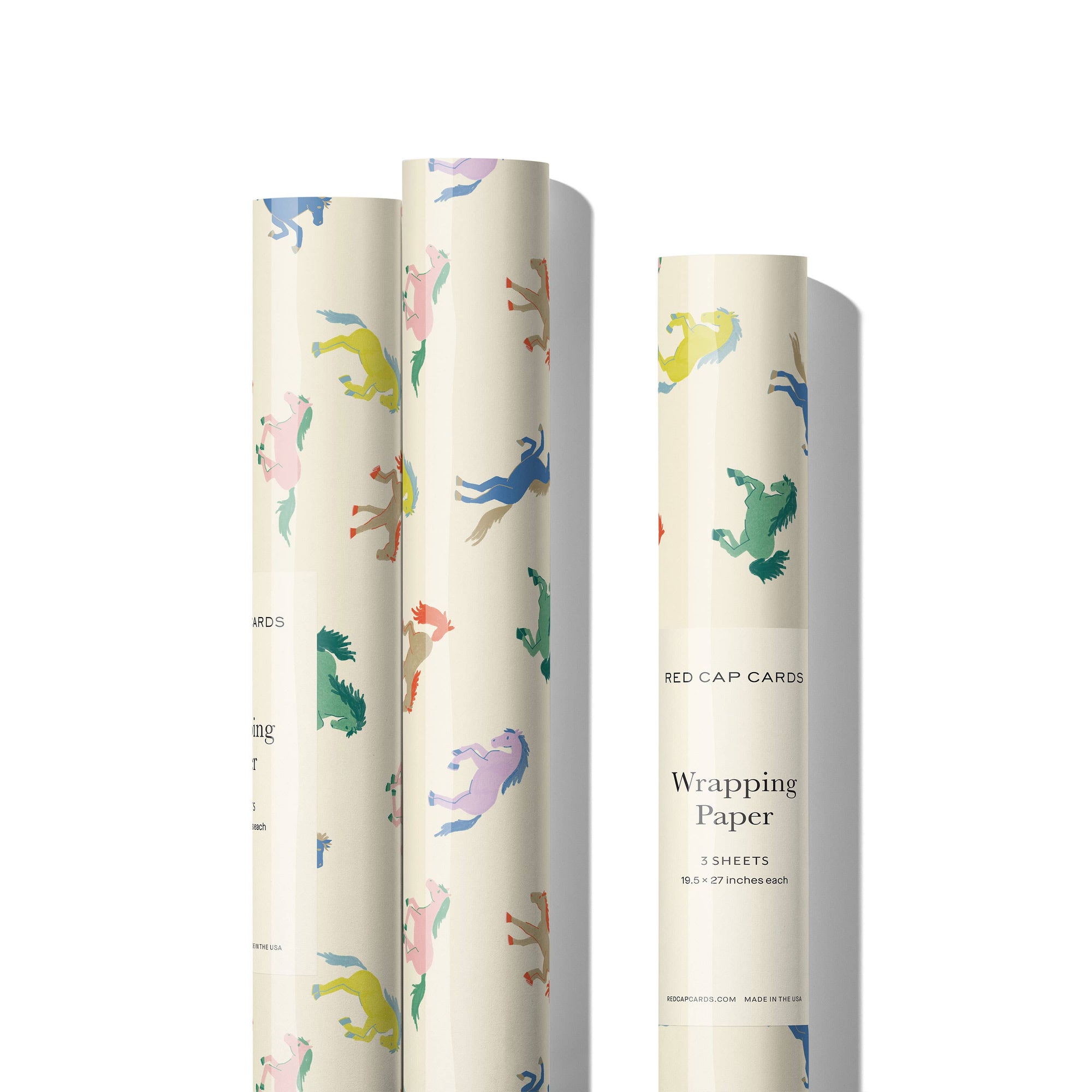 Three rolls of wrapping paper with colorful animal designs on a white background