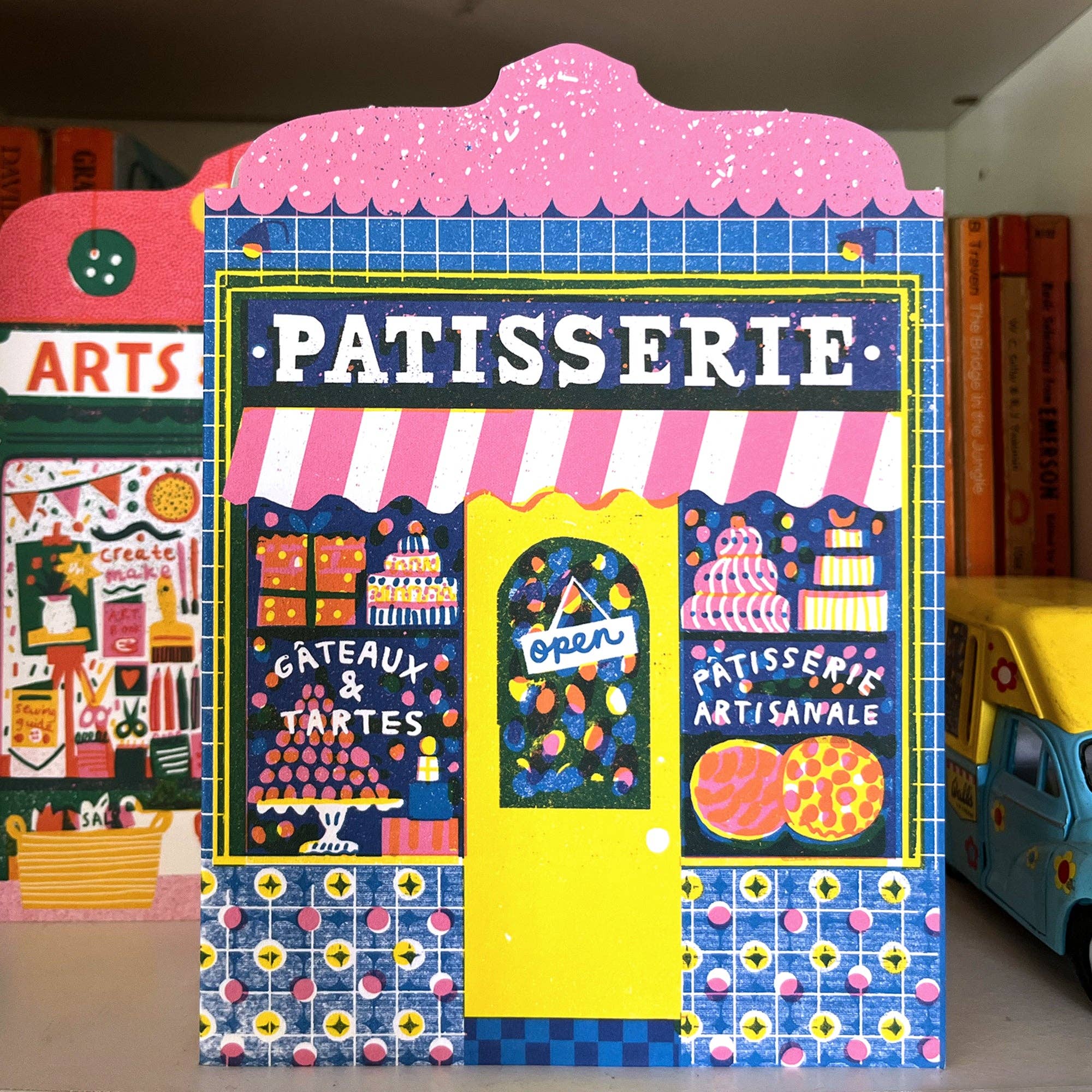Colorful display of a 'Patisserie' themed stand with various elements.